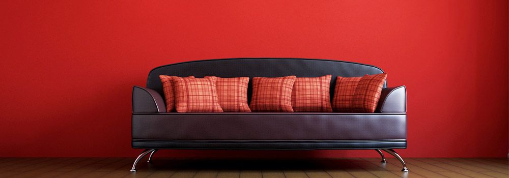 salon avec un mur rouge et un canapé en cuir