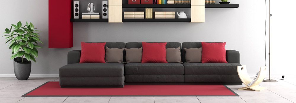 salon avec canapé noir et tapis rouge