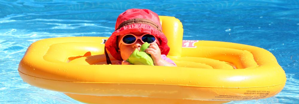 bébé dans une piscine avec bouée jaune