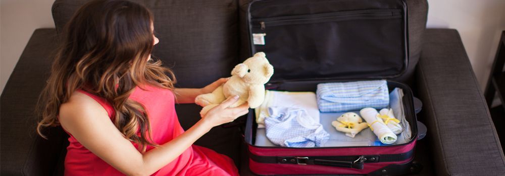 femme préparant sa valise pour la naissance de bébé