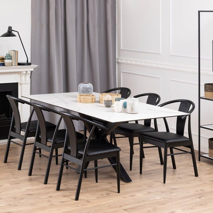 Table à manger Hennie, 200x100 cm, avec plateau blanc en céramique et pieds croisés en métal noir mat.
