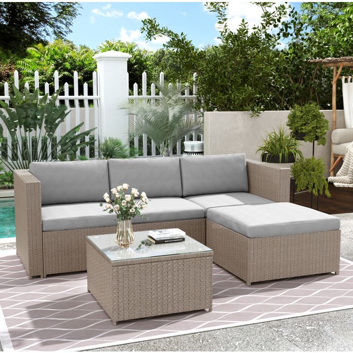 Salon de jardin en rotin. table basse carrée en verre 58×58×36 cm. canapé dangle modulable. coussins gris clair. acier
