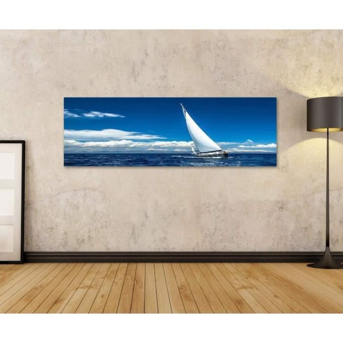 Tableau sur toile Un bateau blanc avec voile rouge contre le bleu de la mer * Pi