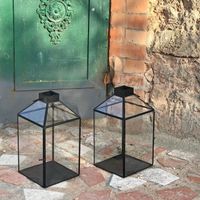 Set de 2 lanternes en verre et laiton Dimension Produit : Longueur 17 cm x Largeur 17 cm x Hauteur 33 cm Noir