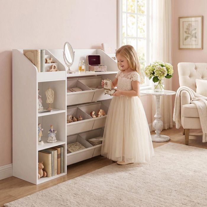 Une bibliothèque pour enfants en bois blanc dotée de six tiroirs en tissu elle offre un vaste espace de rangement pour