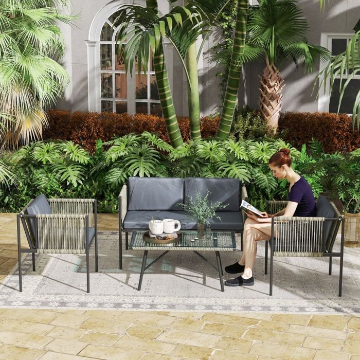 Mobilier de jardin comprenant un canapé deux fauteuils une table en verre des coussins et du rotin synthétique de couleur grise