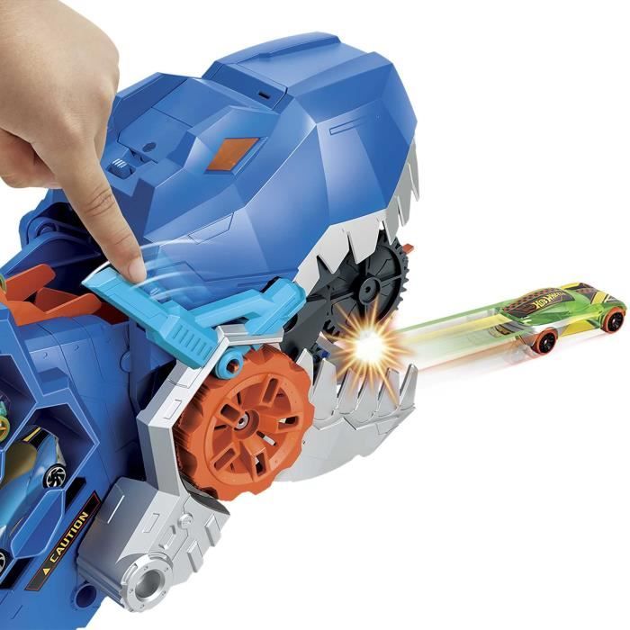 Hot Wheels Ensemble de piste de voitures de jouets de la ville, transporteur ultime T-Rex, transporteur se transforme en dino piétinant avec piste de course, de la série Netflix «Let's Race